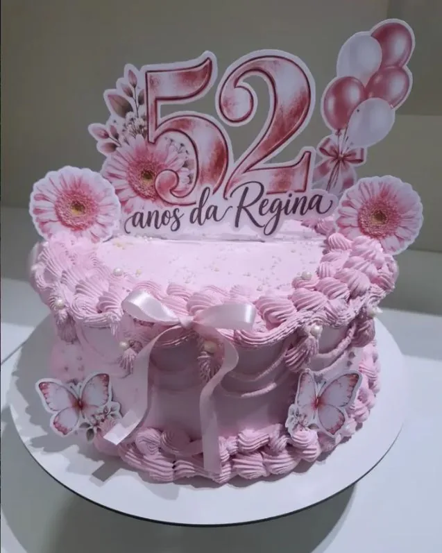 Bolo rosa de chantilly com flores e borboletas